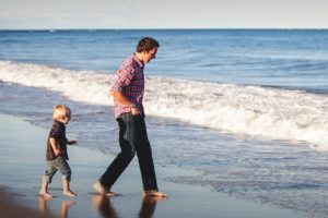 Ensamstående pappa med sitt barn på en strand